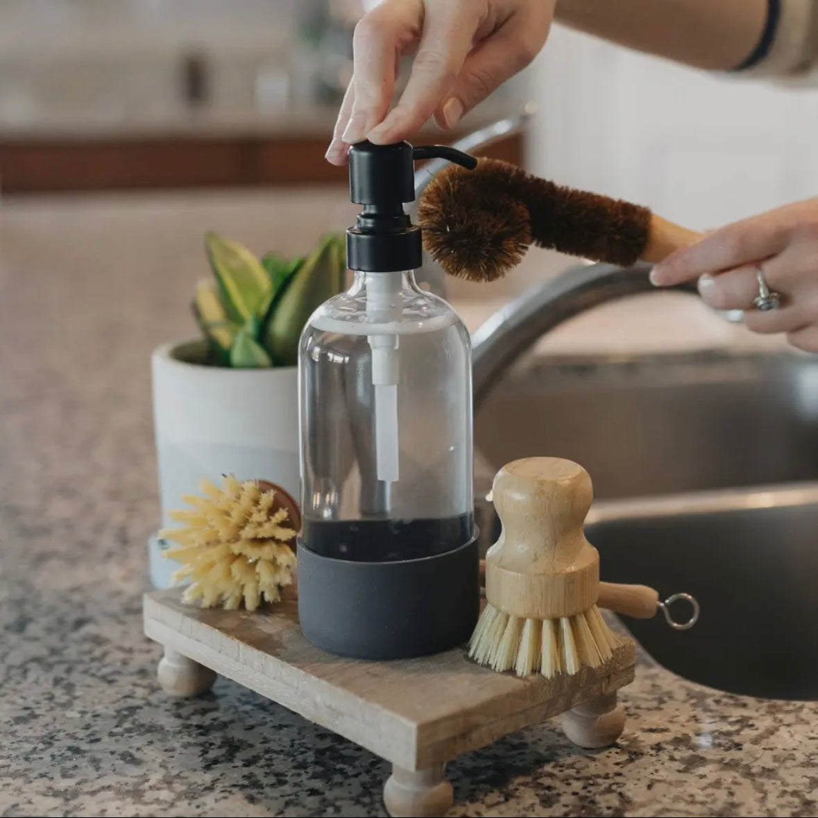 Clear bottle with dark grey silicone sleeve covering the bottom portion.