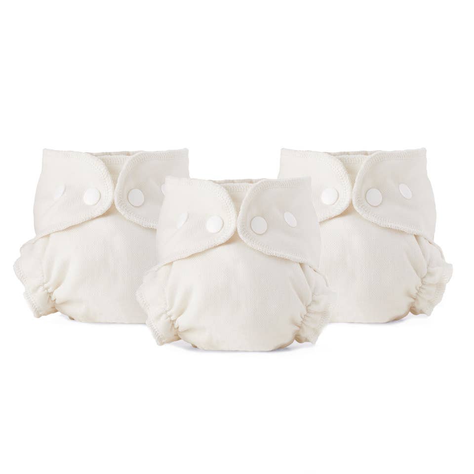 Three white cloth diaper inserts on a white background