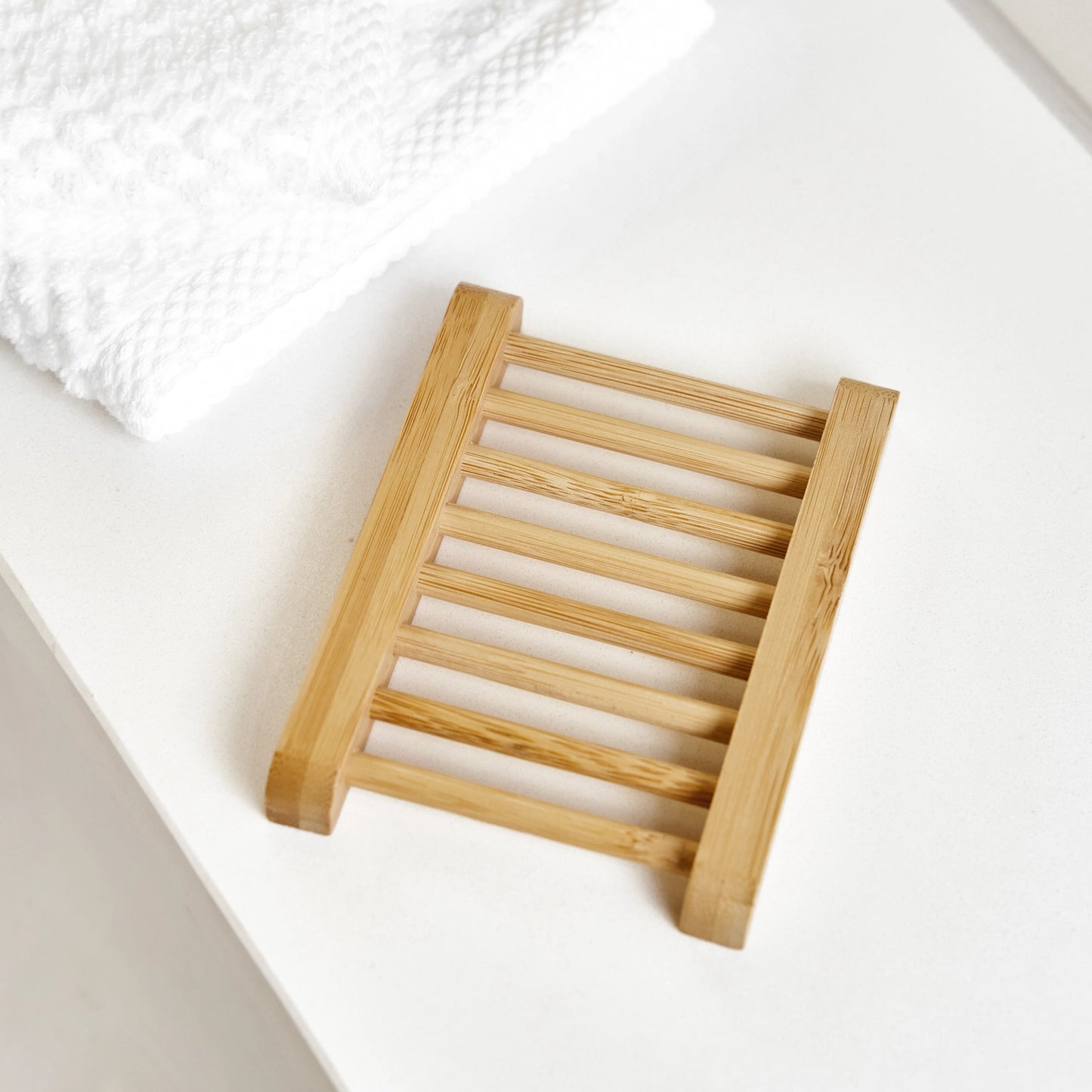 Wooden, ladder shaped soap dish on a white surface