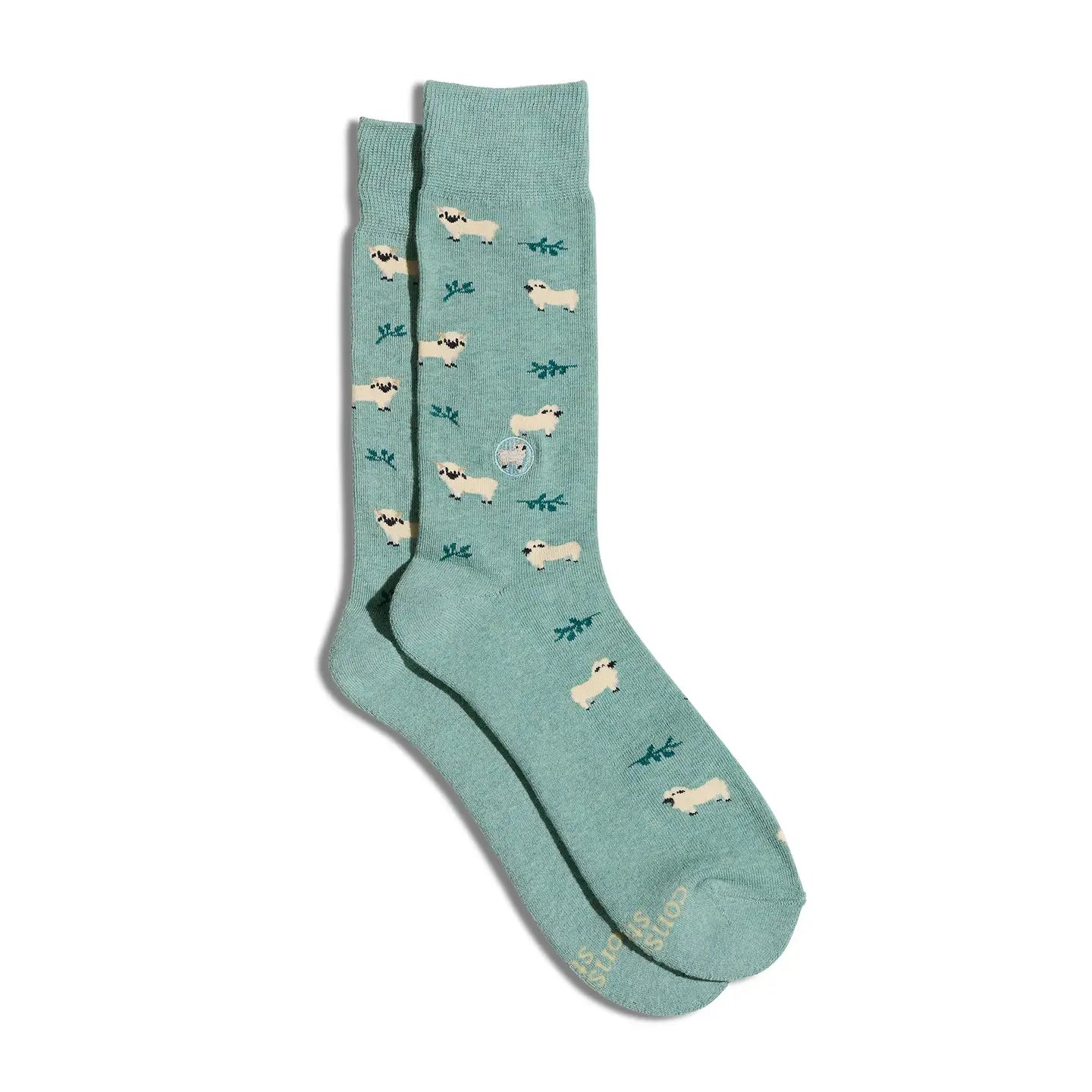 Pair of green socks with sheep illustrations on a white background