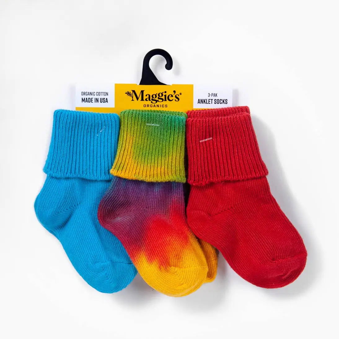 Three pairs of colorful socks on a hanger with 'Maggie's Organics' label.