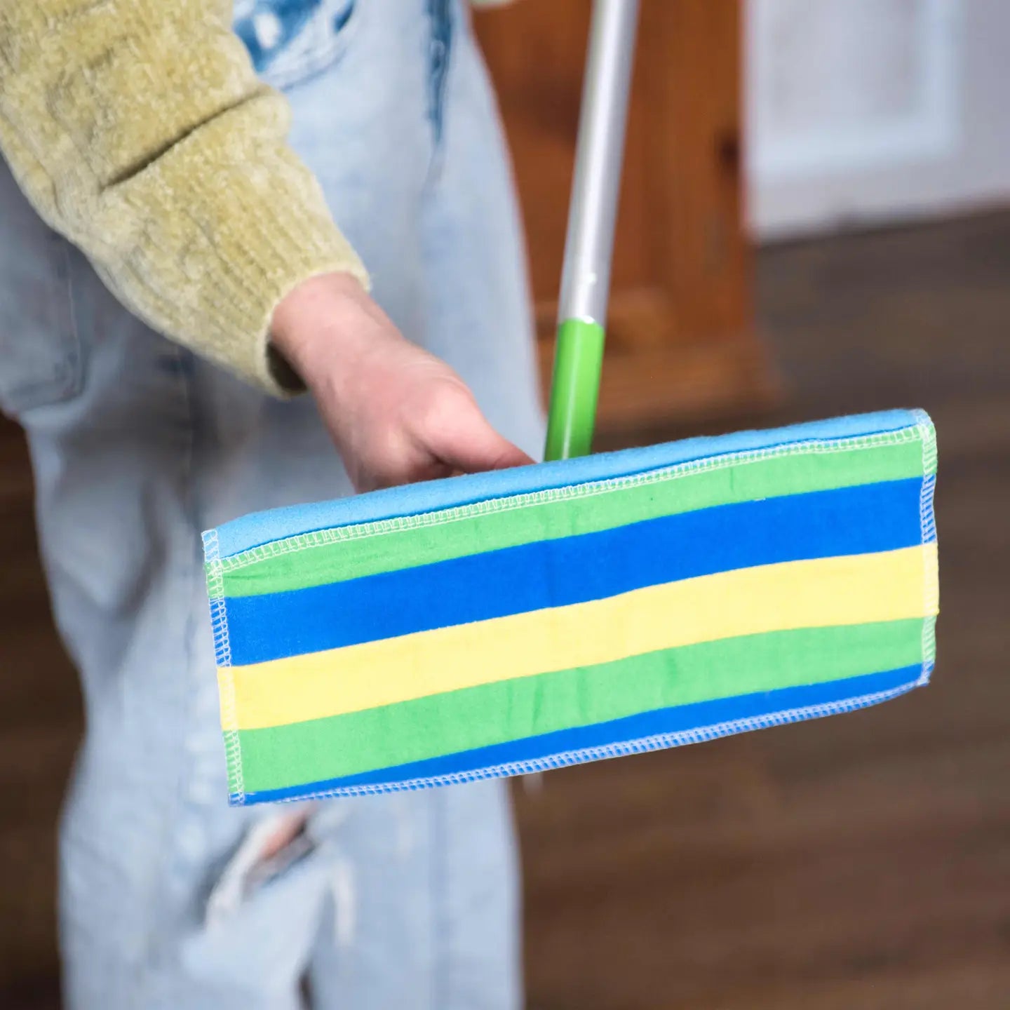 Random rainbow print reusable mop pad on a swiffer mop. 