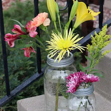 Decorative mason jars with flowers on a ledge