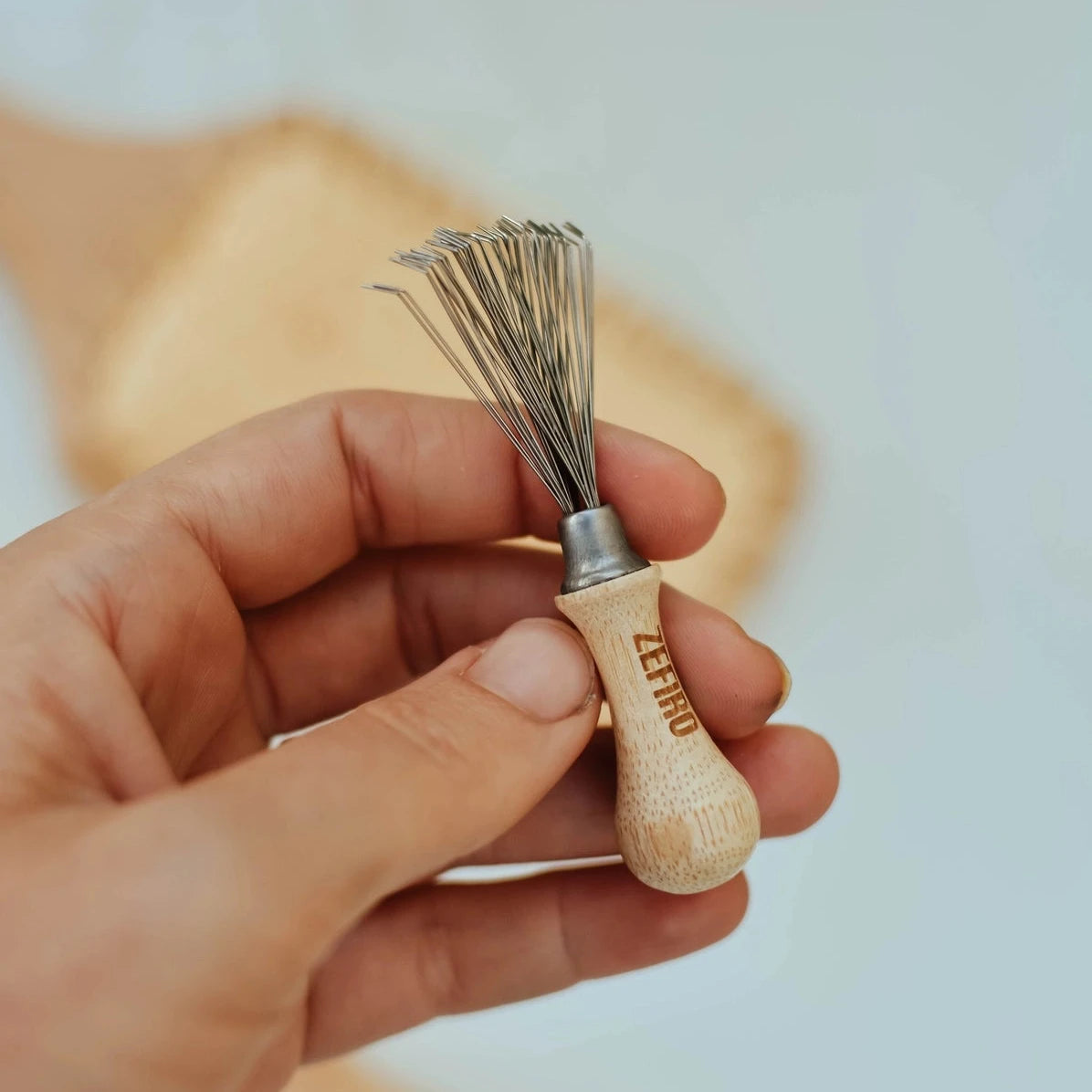 Hairbrush cleaning tool with wood handle and metal comb. 